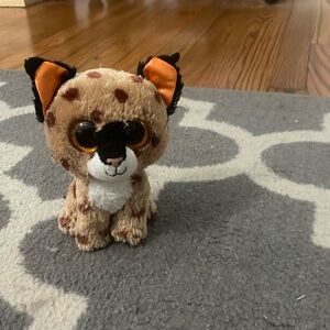 White and brown stuffed animals with orange eyes and orange and black ears